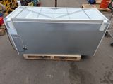 a silver refrigerator sitting on a pallet in a warehouse