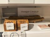 two boxes of candles sitting on top of a refrigerator