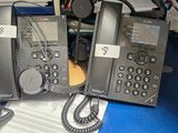 deux téléphones posés sur un bureau encombré de livres