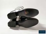 pair of black leather shoes with silver straps on a white background