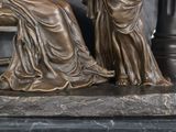 a statue of a woman sitting on a bench next to a statue of a man