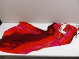 a red and pink scarf laying on a white table
