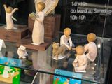 many figurines of angels on display in a glass case