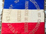 flags are hanging on a wall with fringes on them