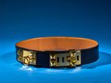 black leather dog collar with gold studs on a blue background