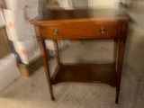 a small table with a drawer on it in a room