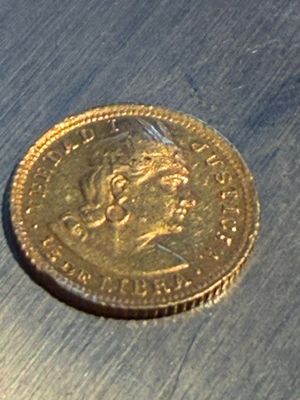 une pièce d'or posée sur une surface métallique