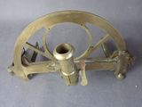 un télescope ancien plaqué laiton posé sur une surface grise