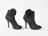 two pairs of black high heeled shoes with a flower on the heel