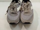 pair of grey and white sneakers with laces on them on a white surface