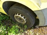 a yellow car that is sitting in the grass