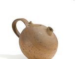 un vase brun posé sur une surface blanche
