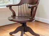 a wooden chair sitting in front of a window on a hard wood floor