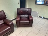 two brown leather chairs in a room with a flat screen tv