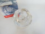 a clear glass candle holder sitting next to a box of snowballs