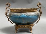 a blue and gold vase on a stand with a dragon on it