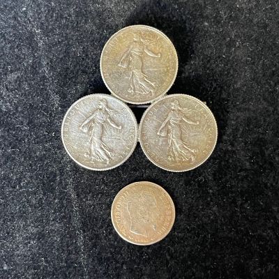 three british coins sitting on top of each other on a black surface