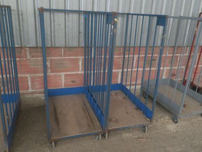 trois cages en acier bleu sont alignées contre un mur de briques