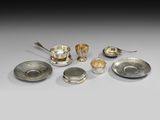 un ensemble d'assiettes et de cuillères en métal argenté posées sur une table