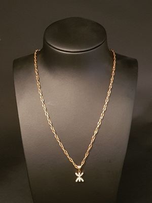 a gold necklace with a cross pendant on a mannequin