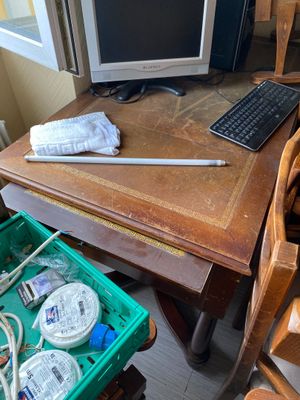 a desk with a computer, keyboard, mouse, and other items on it