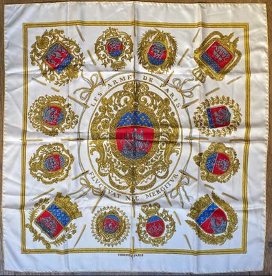 a white and gold scarf with a picture of a coat of arms