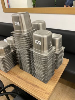 a stack of silver containers sitting on a wooden table