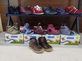 several pairs of children ' s shoes are lined up on a shelf