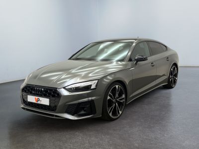 Une Audi RS4 grise est garée dans une grande pièce