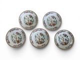 quatre petites assiettes ornées de motifs floraux sur un fond blanc