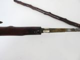 someone is holding a knife with a wooden handle on a white surface