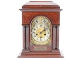 a wooden clock that is sitting on a white surface