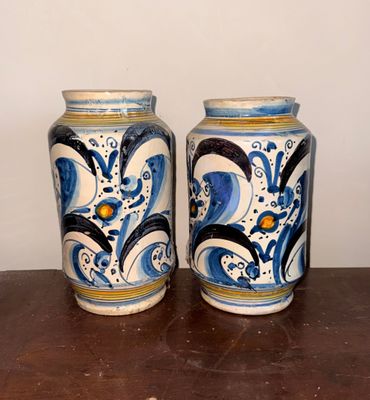 deux vases posés sur une table en bois, avec un mur blanc en arrière-plan