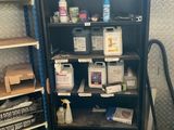 une bibliothèque noire sur laquelle sont disposés de nombreux objets divers