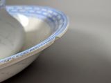 a blue and white bowl and a white vase on a table