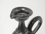a black vase with a handle on a white background