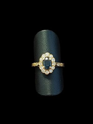 un gros plan d'une bague posée sur une surface noire, avec un fond noir