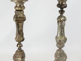 pair of antique brass candlesticks on pedestals on a white background