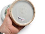 a person holding a white bowl with a sticker on it