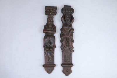 two wooden carvings on the wall next to each other