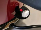 a close up of a red laptop with a black cord