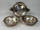 three silver plate bowls with handles and handles on a white surface