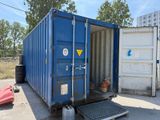 a blue shipping container sitting in the middle of a parking lot