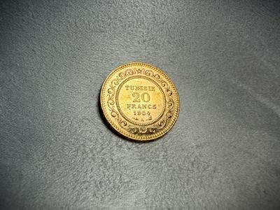 a close up of a gold coin on a gray surface