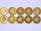 six types différents de pièces d'or sur une surface blanche