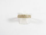 gros plan d'une bague en or sur une surface blanche