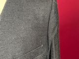 a close up of a woman ' s gray jacket with a red background