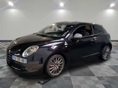 la photo d'une petite voiture noire garée sur un sol en damier