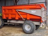 a tractor that is parked next to a dump truck
