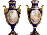 pair of blue and gold vases with a painting on them